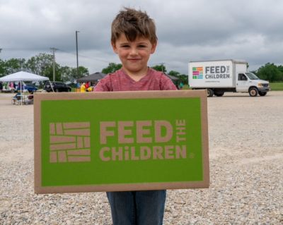 Boy with feed the children sign